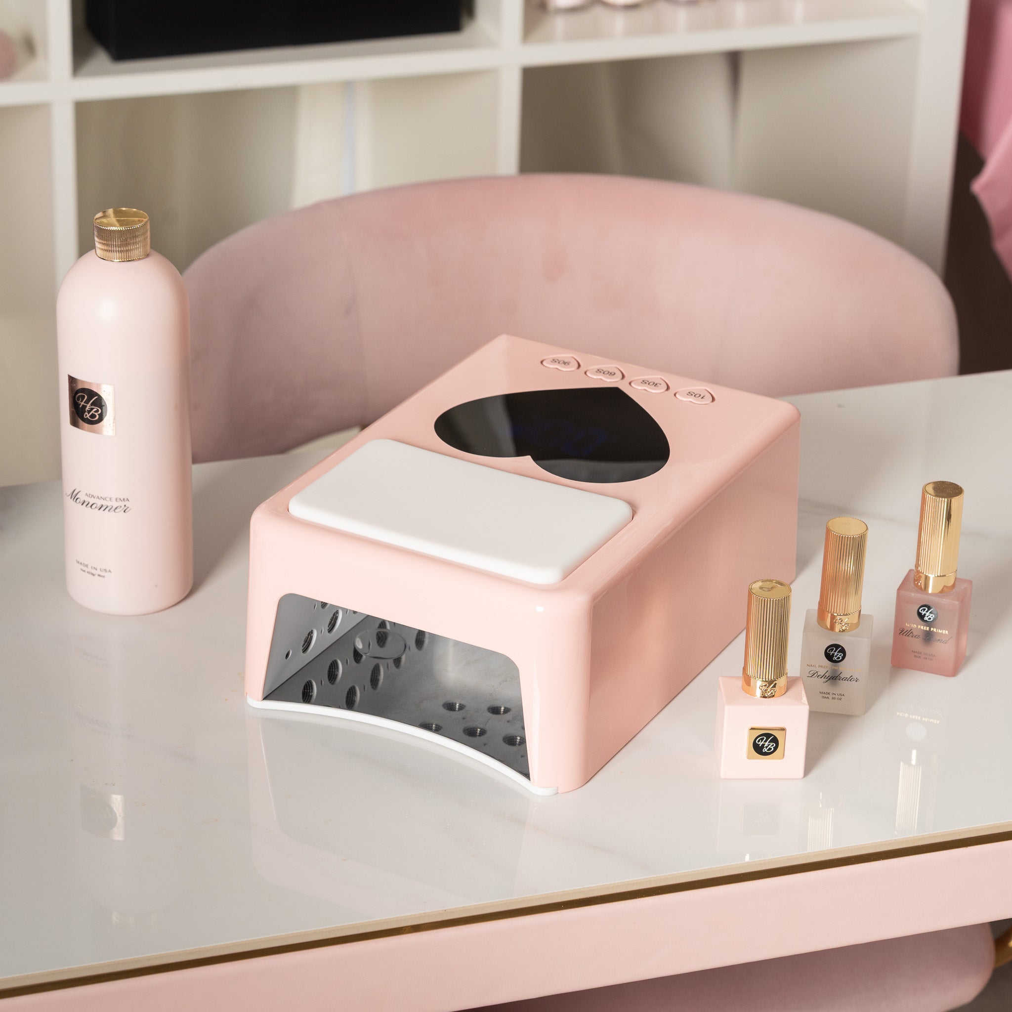 Pink nail dryer on a table with cosmetic products