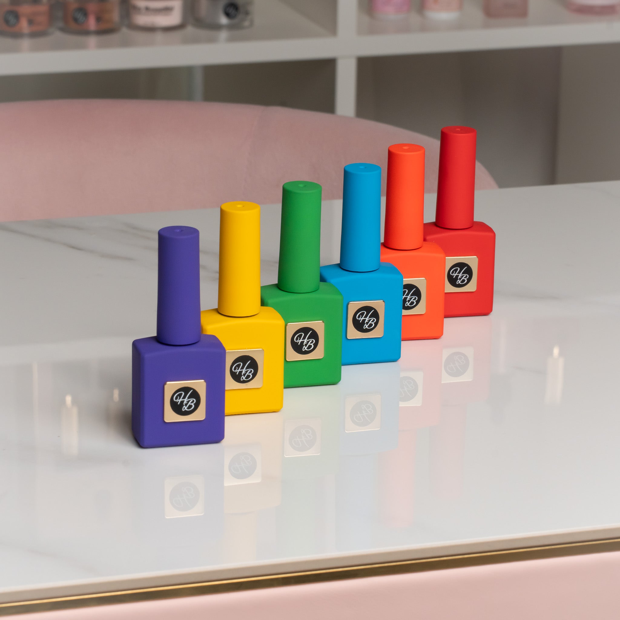 Hand holding bold gel polish swatches with colorful bottles in the background