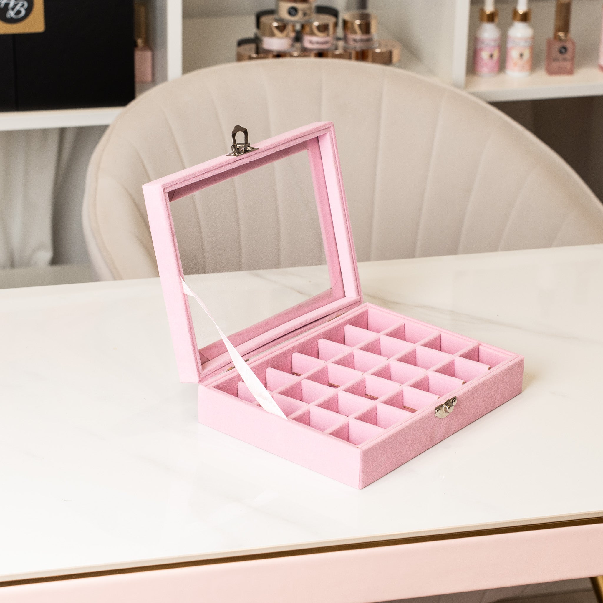 Pink jewelry box with compartments on a white surface